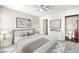 Virtually staged main bedroom features a ceiling fan, comfy bed, and ensuite bath at 6800 E Lake Mead Blvd # 1018, Las Vegas, NV 89156