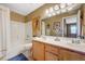 Bright bathroom featuring double sinks, a large mirror, a shower/tub, and wood-look tile flooring at 7488 Evening Falls Dr, Las Vegas, NV 89131