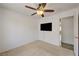 Bright bedroom featuring neutral walls and carpet, fan with light, and mounted flatscreen TV at 7488 Evening Falls Dr, Las Vegas, NV 89131