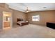 A large bedroom features neutral walls, carpet flooring, a ceiling fan, and a large bed at 7488 Evening Falls Dr, Las Vegas, NV 89131