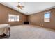 Bright, large bedroom with vaulted ceiling, two windows, neutral walls, ceiling fan, and carpet flooring at 7488 Evening Falls Dr, Las Vegas, NV 89131