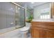 Cozy bathroom featuring a shower-tub combo with stylish tile and a wood vanity at 8244 Horseshoe Bend Ln, Las Vegas, NV 89113