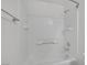 Clean, white tiled bathtub and shower combination featuring sleek fixtures and recessed shelf at 9100 Hombard Ave, Las Vegas, NV 89148