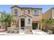 Two-story home showcasing an inviting entry and attached garage, complemented by manicured landscaping, exuding curb appeal at 9100 Hombard Ave, Las Vegas, NV 89148