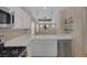 Modern kitchen highlighting a stainless steel dishwasher, double sink, and white cabinetry, offering a sleek design at 9100 Hombard Ave, Las Vegas, NV 89148