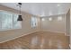 Empty living room featuring laminate wood flooring and bright windows with shutters at 9100 Hombard Ave, Las Vegas, NV 89148