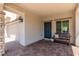 Inviting covered entrance featuring a brick-paved patio with a cozy bench and a view of the garage at 1034 Fish Pond Ave, Henderson, NV 89014