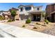 Inviting two-story home showcasing a paved driveway, stone-accented columns, and attractive desert landscaping at 1034 Fish Pond Ave, Henderson, NV 89014