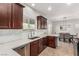 Open-concept kitchen featuring dark wood cabinets, stainless steel appliances, and a view into the dining area at 1034 Fish Pond Ave, Henderson, NV 89014