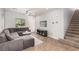 Inviting living room featuring a plush sectional sofa, tile floors, and a staircase leading upstairs at 1034 Fish Pond Ave, Henderson, NV 89014