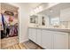 Bathroom featuring dual sinks, a walk-in closet with ample storage, and quartz countertops at 10650 Dryades Ave, Las Vegas, NV 89166