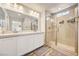 Modern bathroom with double sink vanity, quartz countertops, and tiled walk-in shower at 10650 Dryades Ave, Las Vegas, NV 89166
