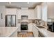 Modern kitchen with stainless steel appliances, white cabinetry, and granite countertops at 10650 Dryades Ave, Las Vegas, NV 89166