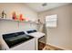 Efficient laundry room with shelving, a window, and modern washer/dryer units at 10650 Dryades Ave, Las Vegas, NV 89166