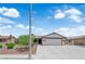 Single-story home with a two-car garage and a well-manicured front yard under a partly cloudy sky at 1105 Winwood St, Las Vegas, NV 89108