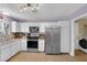 Bright kitchen features stainless steel appliances, white cabinetry, and tan tile floors at 1105 Winwood St, Las Vegas, NV 89108