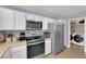 Kitchen with stainless steel appliances, white cabinets, tile backsplash and access to the laundry room at 1105 Winwood St, Las Vegas, NV 89108