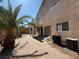 Paver patio with palm trees, covered area, and second story deck create an appealing backyard space at 1177 Twinkling Meadows Dr, Henderson, NV 89012