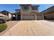 Two-story home featuring a large driveway, three-car garage and neutral toned stucco exterior at 1177 Twinkling Meadows Dr, Henderson, NV 89012