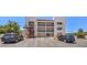 Three-story exterior with balconies, stairs, and parking lot on a sunny day in a lush outdoor setting at 1381 E University Ave # 204, Las Vegas, NV 89119