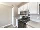 This kitchen features white cabinets, stainless steel microwave, and a black oven at 1381 E University Ave # 204, Las Vegas, NV 89119