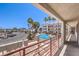 A swimming pool on a sunny day with palm trees and an apartment complex at 1381 E University Ave # 204, Las Vegas, NV 89119