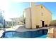 Spacious backyard featuring a covered patio, private pool, lush landscaping, and a pristine lawn at 2140 Desert Peak Rd, Las Vegas, NV 89134
