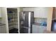 Modern kitchen area equipped with stainless steel refrigerator and organized pantry shelves at 2140 Desert Peak Rd, Las Vegas, NV 89134