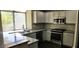 Well-lit kitchen features granite countertops, stainless appliances, and sleek dark hardwood floors at 2140 Desert Peak Rd, Las Vegas, NV 89134