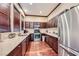 Galley kitchen featuring stainless steel appliances, dark wooden cabinets and tiled backsplash at 251 S Green Valley Pkwy # 3222, Henderson, NV 89012