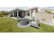 Spacious backyard with a fire pit, comfortable chairs, covered patio, and beautifully manicured artificial grass at 2616 Faiss Dr, Las Vegas, NV 89134