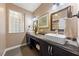 Elegant bathroom featuring dual vessel sinks, a dark vanity, and a decorative window at 2616 Faiss Dr, Las Vegas, NV 89134