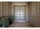 Inviting front entryway featuring a modern double door with glass panels, flanked by glass block windows and potted plants at 2616 Faiss Dr, Las Vegas, NV 89134