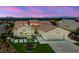 Single-story home featuring a well-manicured lawn, elegant landscaping, and two-car garage at dusk at 2616 Faiss Dr, Las Vegas, NV 89134