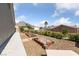Side yard garden featuring raised garden beds, mature hedges, gravel, and hillside views in the distance at 2616 Faiss Dr, Las Vegas, NV 89134