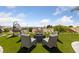 Backyard sitting area with comfortable chairs, a fire pit, and a hanging swing chair, ideal for outdoor relaxation at 2616 Faiss Dr, Las Vegas, NV 89134