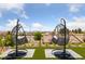 Relaxing backyard featuring comfortable hanging swing chairs and beautiful landscaping with hillside views in the distance at 2616 Faiss Dr, Las Vegas, NV 89134
