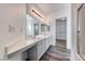 Bathroom featuring a double sink vanity, large mirror, modern lighting, and access to the closet at 2766 Red Vista Ct, Henderson, NV 89074