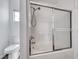 Bathroom with a tub-shower combo and sliding glass doors, as well as a toilet and window at 2766 Red Vista Ct, Henderson, NV 89074