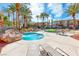 Relaxing community hot tub area with lounge chairs, palm trees, and manicured landscaping at 2766 Red Vista Ct, Henderson, NV 89074