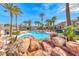 Beautiful community pool area, complete with rocks, palm trees, lounge area and clear blue water at 2766 Red Vista Ct, Henderson, NV 89074