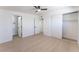 This bedroom has a light-colored wood floor, ceiling fan, closet with sliding doors and access to an en-suite bathroom at 2854 La Canada St, Las Vegas, NV 89169
