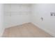 Laundry area has light-colored wood floors and white walls, along with upper shelving and water hookups at 2854 La Canada St, Las Vegas, NV 89169