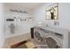 The laundry room is virtually staged with a side-by-side washer/dryer and upper shelving at 2854 La Canada St, Las Vegas, NV 89169