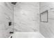 Close up of the tiled shower and tub with a shelf insert and black fixtures at 2854 La Canada St, Las Vegas, NV 89169