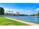Scenic view of the community lake with lush greenery, palm trees, and bridge at 3125 N Buffalo Dr # 1133, Las Vegas, NV 89128