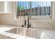 A close-up showcases the kitchen sink with a gooseneck faucet and quartz countertop at 3320 Osage Ave, Las Vegas, NV 89101