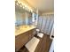 Bathroom features a double vanity, ample lighting, decorative mirror, and shower with curtain at 39 Belle La Blanc Ave, Las Vegas, NV 89123