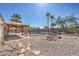 Backyard view of a pool, patio, desert landscaping, and rock fire pit at 4010 Hemphill St, North Las Vegas, NV 89032