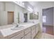 Bathroom features a double sink vanity with tile countertops and bright lighting at 4010 Hemphill St, North Las Vegas, NV 89032